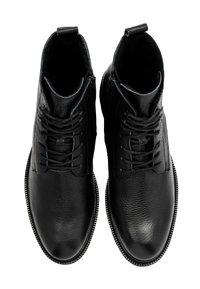 Czarne skórzane botki za kostkę o teksturowanym wykończeniu, z wiązaniem z przodu i zamkiem błyskawicznym z boku dla łatwego zakładania. Płaska gumowa podeszwa.