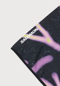 Μαύρο ύφασμα με μωβ και πράσινο αφηρημένο σχέδιο, που εμφανίζει το λευκό λογότυπο "SALOMON" κοντά στην επάνω άκρη σε απλό φόντο.