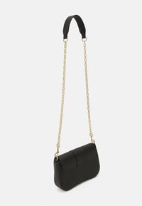 Sac à main en cuir noir avec chaîne dorée et bandoulière en tissu. Présente une forme courbée, une texture lisse, et une poche avant avec des détails cousus.