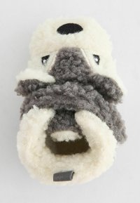 Chausson en forme d'animal en fourrure, en laine texturée crème et grise, avec un nez noir rond et des yeux brodés. Comprend une boucle en tissu gris.