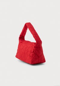 Κουβερτοκυλινδρική κόκκινη τσάντα χειρός με δομημένο τριγωνικό σχήμα και κοντό, μαλακό χερούλι. Διαθέτει φερμουάρ και λεία, γυαλιστερή υφή.