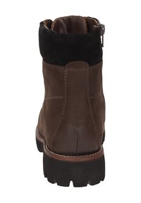 Stivaletto in pelle marrone con colletto in suede nero, chiusura con zip, suola robusta e cuciture a contrasto. Progettato per resistere e per il massimo comfort.