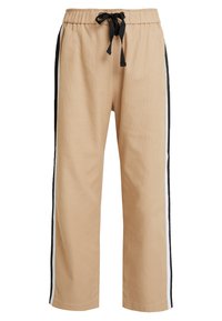 Pantalons de survêtement beige en tissu texturé, avec une taille élastique à cordon de serrage et des bandes latérales noires. Design ample avec des jambes droites.