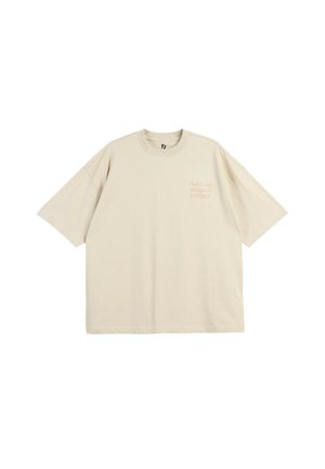 Beżowy, oversize t-shirt z krótkim rękawem, okrągłym dekoltem i małym napisem "That Level SPARKLE EDITION" na lewej piersi.