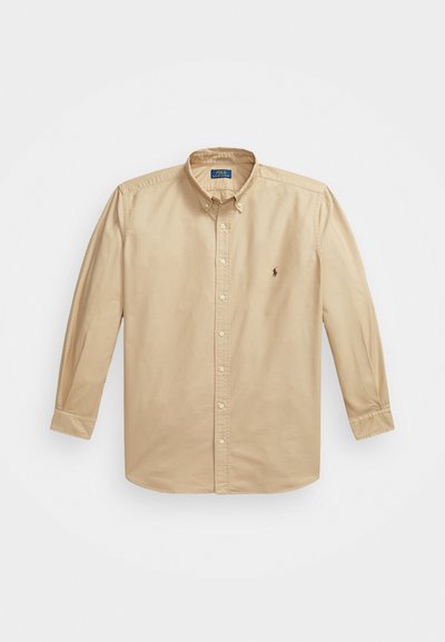 Bežna srajca z dolgimi rokavi in gumbi, izdelana iz bombaža. Ima klasičen ovratnik, zapiranje na gumbe in majhen znak na levem prsnem delu.