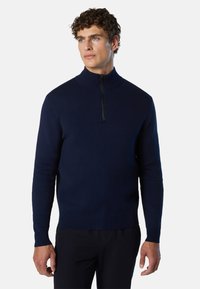 Maglione lavorato a maglia blu navy con colletto alto, zip a metà sul davanti e polsini a coste. Texture liscia e design aderente per comfort e calore.
