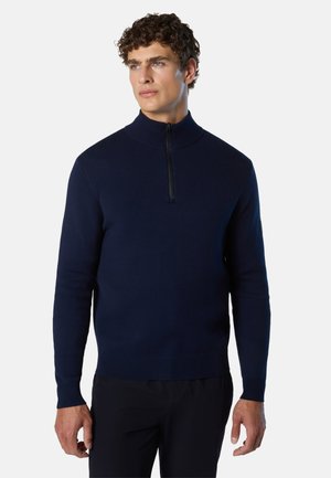 Maglione lavorato a maglia blu navy con colletto alto, zip a metà sul davanti e polsini a coste. Texture liscia e design aderente per comfort e calore.