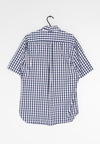 Camisa de manga corta en patrón de cuadro vichy en tonos azul marino y blanco, con un cuello clásico y un corte relajado con dobladillo recto.