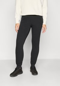 Sorte, tapered sweatpants lavet af blødt materiale med en glat tekstur, der har en elastisk talje og manchetter for komfort.