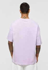 Lavendelkleurig oversized t-shirt van zachte katoen, met korte mouwen en een ronde halslijn. Lichte textuur met een relaxte pasvorm.