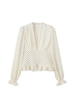 Blusa blanca de manga larga con lunares negros, escote en V profundo, puños fruncidos y bajo con volantes.