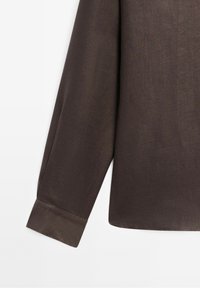 Braunes Langarmhemd mit glatter Textur, spitzem Kragen und geknöpftem Ärmelbündchen. Der Stoff wirkt leicht und leicht glänzend.