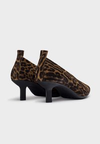 Leopard print high-heeled shoes made of soft fabric, featuring a rounded toe and a slim, black kitten heel. Smooth texture and subtle accents.