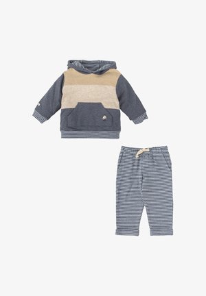 Sudadera con capucha en azul marino, beige y crema, con un bolsillo tipo canguro; pantalones a rayas en azul marino y blanco a juego con una cinturilla elástica.