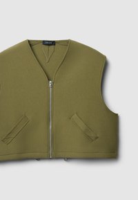 Ärmellose Weste in Olivgrün mit V-Ausschnitt, Frontreißverschluss und zwei Seitentaschen. Besteht aus einem glatten, leicht strukturierten Stoff.