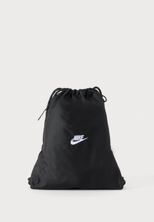 Crna Nike torba s vrpcama i bijelim logotipom u centru na ravnoj svijetloj pozadini.