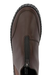 Bota de cuero marrón con puntera redondeada, cremallera lateral y suela de goma negra texturizada. Acabado suave con acentos en contraste en los laterales.