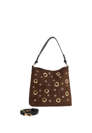 Bolso de ante marrón con tachuelas circulares doradas y una correa negra para el hombro, mostrado con una correa negra adicional desmontable sobre un fondo blanco.