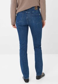 Jeans skinny in denim blu scuro, con vita media, design classico a cinque tasche e dettagli di cucitura discreti.