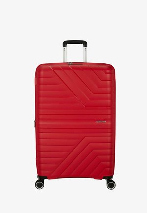 Roter Hartschalenkoffer mit diagonalen Rillen, vier drehbaren Rollen, ausziehbarem schwarzem Griff und "American Tourister"-Logo auf der Vorderseite.