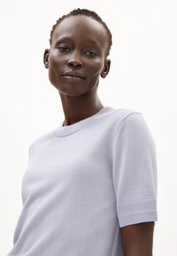 Licht lavendelkleurige sweater met korte mouwen, voorzien van een geribde halslijn en mouwmanchetten. Gemaakt van zachte stof met een gladde textuur. Eenvoudig, klassiek ontwerp.