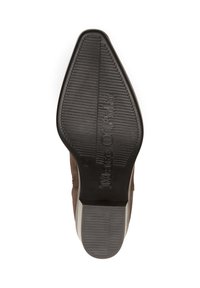 Chaussure en daim marron avec un orteil lisse et incurvé, et une semelle extérieure en caoutchouc noir texturé comportant des rainures horizontales et un logo.