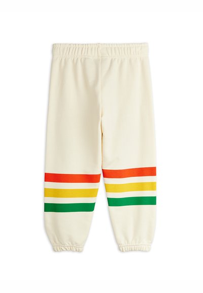 Pantalones de cintura elástica color crema con puños elásticos y rayas horizontales rojas, amarillas y verdes cerca del dobladillo de cada pierna.