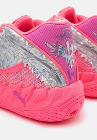 Adidași atletici roz și argintii prezintă un upper texturat cu detalii din plasă, un design unic în formă de aripă și un outsole cu un model îndrăzneț.