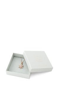 Rosaguld halskæde med en vedhæng, der har et solblomstdesign, præsenteret i en lys grå tekstureret smykkeske med gulds detaljer.