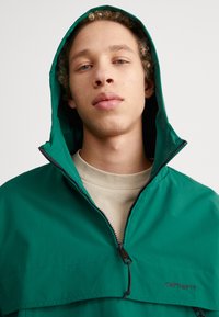 Carhartt WIP Jachetă de vânt - chervil/black
