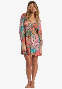 Blumenkleid in lebhaften Pink-, Grün- und Orangetönen. Lange Ärmel, Empire-Taillenschnitt und ein weit ausgestellter Rock mit verschiedenen Mustern.