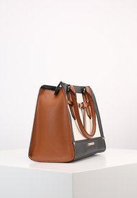 Borsa sintetica marrone e nera con una forma strutturata, caratterizzata da lati testurizzati, doppi manici e una piastra decorativa color oro.