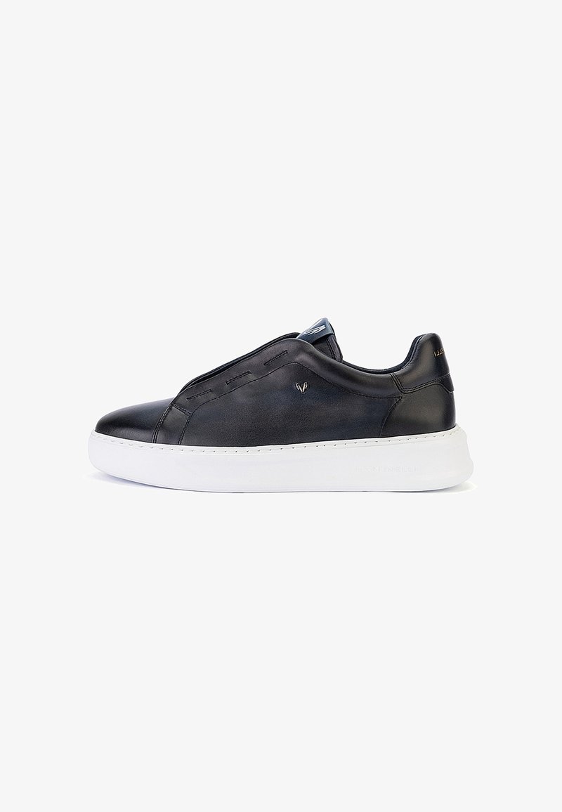 Baskets en cuir noir avec semelle épaisse blanche, design bas et détails de couture minimalistes, vues de profil sur fond blanc.