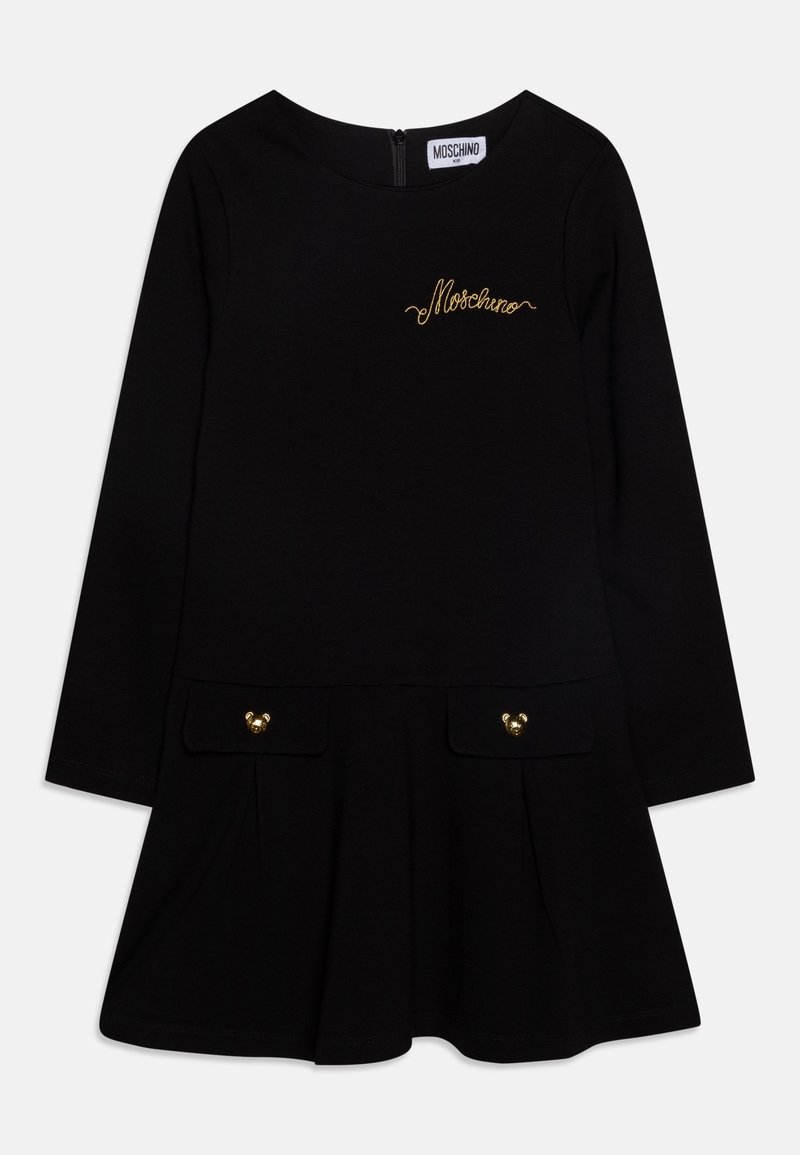 Robe noire à manches longues avec l'inscription Moschino dorée sur la poitrine, deux poches à rabat devant avec boutons ourson dorés et une jupe évasée.