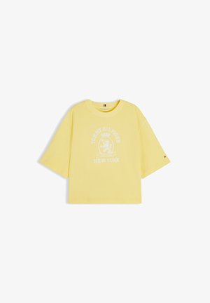 Yellow oversized short-sleeve t-shirt with white crest logo and "Tommy Hilfiger New York" text on front.