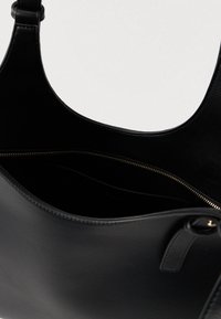 Černá kožená taška s kulturou a zlatým zipem, částečně otevřená, ukazující vnitřní kapsu a hladký texturovaný materiál.