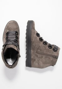 Sneaker con zeppa in suede grigio, lacci in satin nero, superficie texturizzata, suole in gomma e zip laterale per un facile accesso.