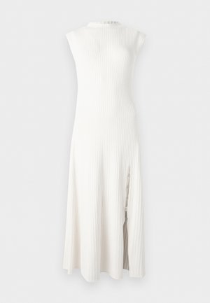 Robe midi blanche sans manches en maille côtelée, avec un col montant et une fente latérale ornée de détails en chaîne décorative.