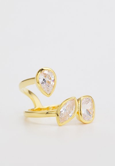 Goldfarbener Ring mit drei klaren, facettierten Edelsteinen in Tropfen- und Ovalformen, auf einem verstellbaren Band montiert.
