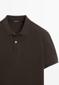 Donkerbruin poloshirt met korte mouwen, een kraag en twee knopen, van een gestructureerde stof, plat gelegd op een witte achtergrond.