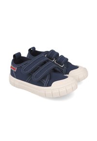 Zapatos de lienzo marinero con suela de goma blanca, que cuentan con dos correas de Velcro y costuras en contraste en la parte superior, puntera redonda y suela texturada.