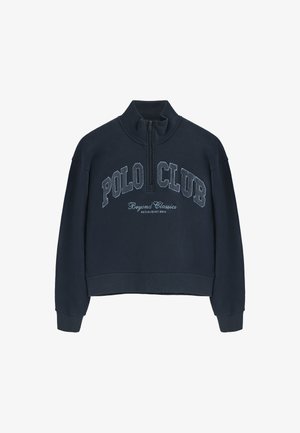 Marineblauwe crop sweatshirt met een hoge kraag en een halve rits. Bevat de tekst "POLO CLUB" en heeft een gladde stoftextuur.