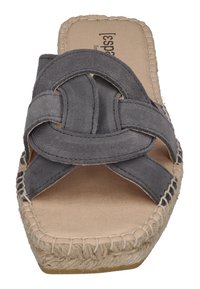 Gray suede slide sandal with a crisscross strap design, jute sole, and stitching detail along the edge. Flat, open-toe style.