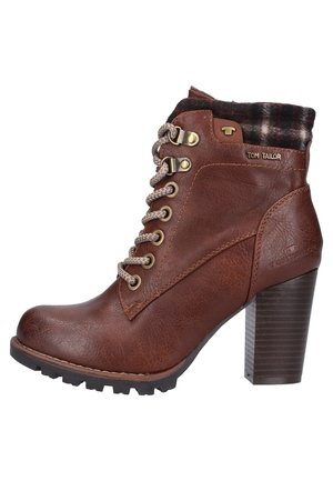 Bottine en cuir marron avec talon épais, lacets beige, bord en tissu à carreaux et œillets métalliques, marquée "Tom Tailor" sur le côté et le talon.