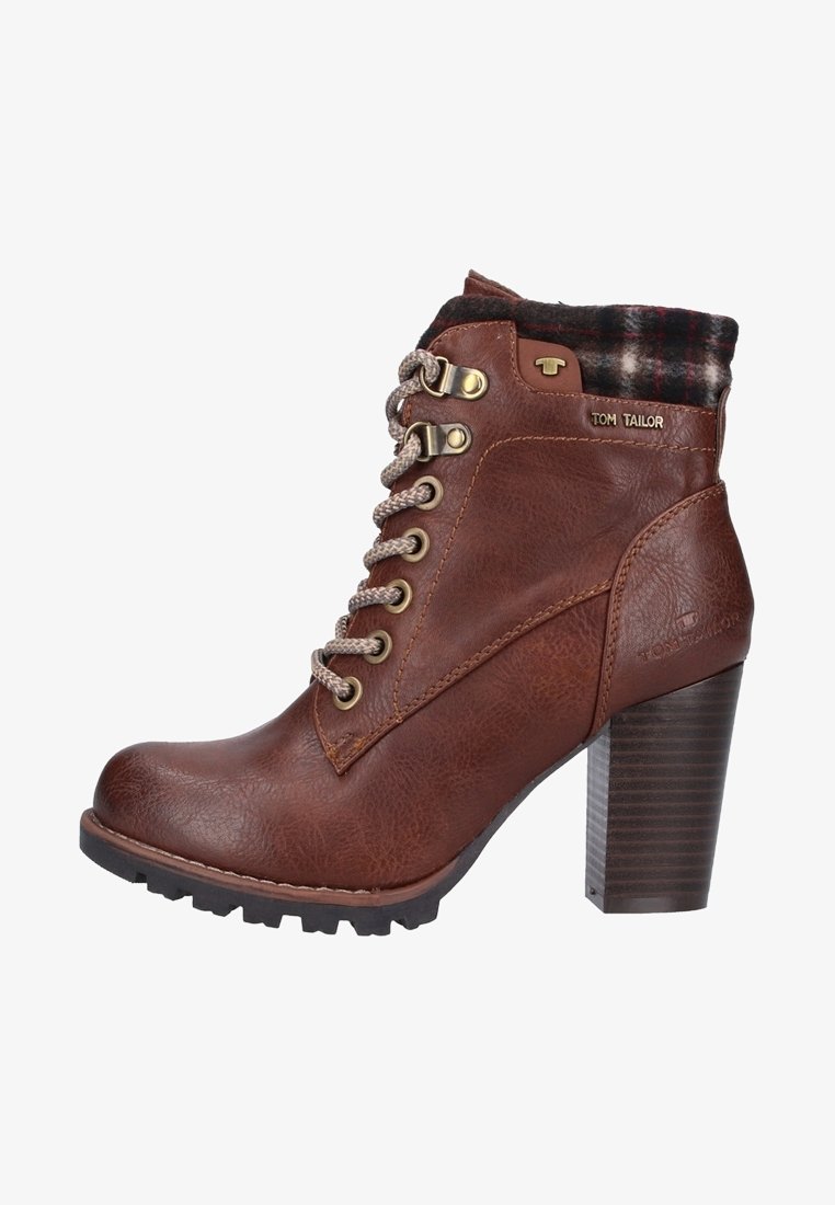 Bottine en cuir marron avec talon épais, lacets beige, bord en tissu à carreaux et œillets métalliques, marquée "Tom Tailor" sur le côté et le talon.