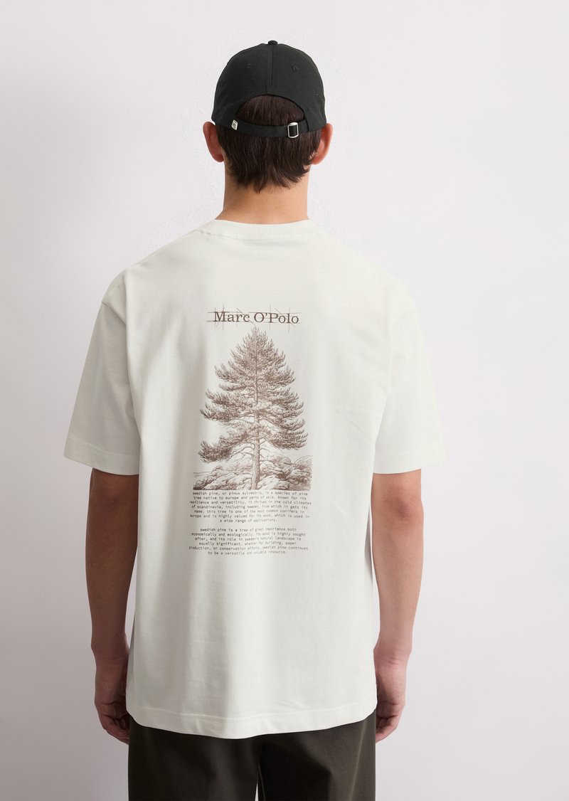 White short-sleeve t-shirt featuring a brown graphic of a tree and text on the back, round neckline, soft fabric, and relaxed fit.