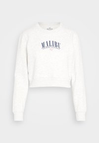 Bílý zkrácený svetr s dlouhými rukávy. Na přední straně potisk "MALIBU SOUTHERN CALIFORNIA" v námořnické modři. Měkký materiál, žebrované manžety a dolní lem.
