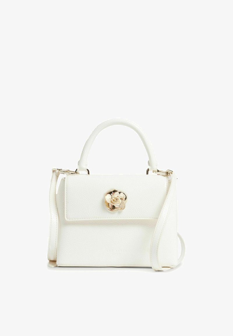 Sac à main en cuir blanc avec poignée supérieure, bandoulière longue amovible et fermoir en forme de fleur dorée sur le rabat avant.