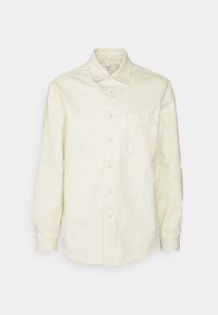 Camicia button-up color crema con maniche lunghe, colletto e una tasca sul petto. Presenta un tessuto testurizzato leggermente spazzolato.