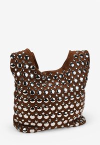 Bolso de ante marrón cubierto de tachuelas plateadas de varios tamaños, con una suave forma rectangular y caída, y asas cortas.